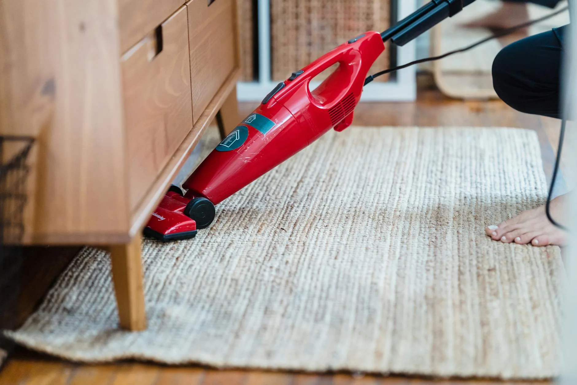 Vacuuming a bedroom carpet to reduce dust and allergens
