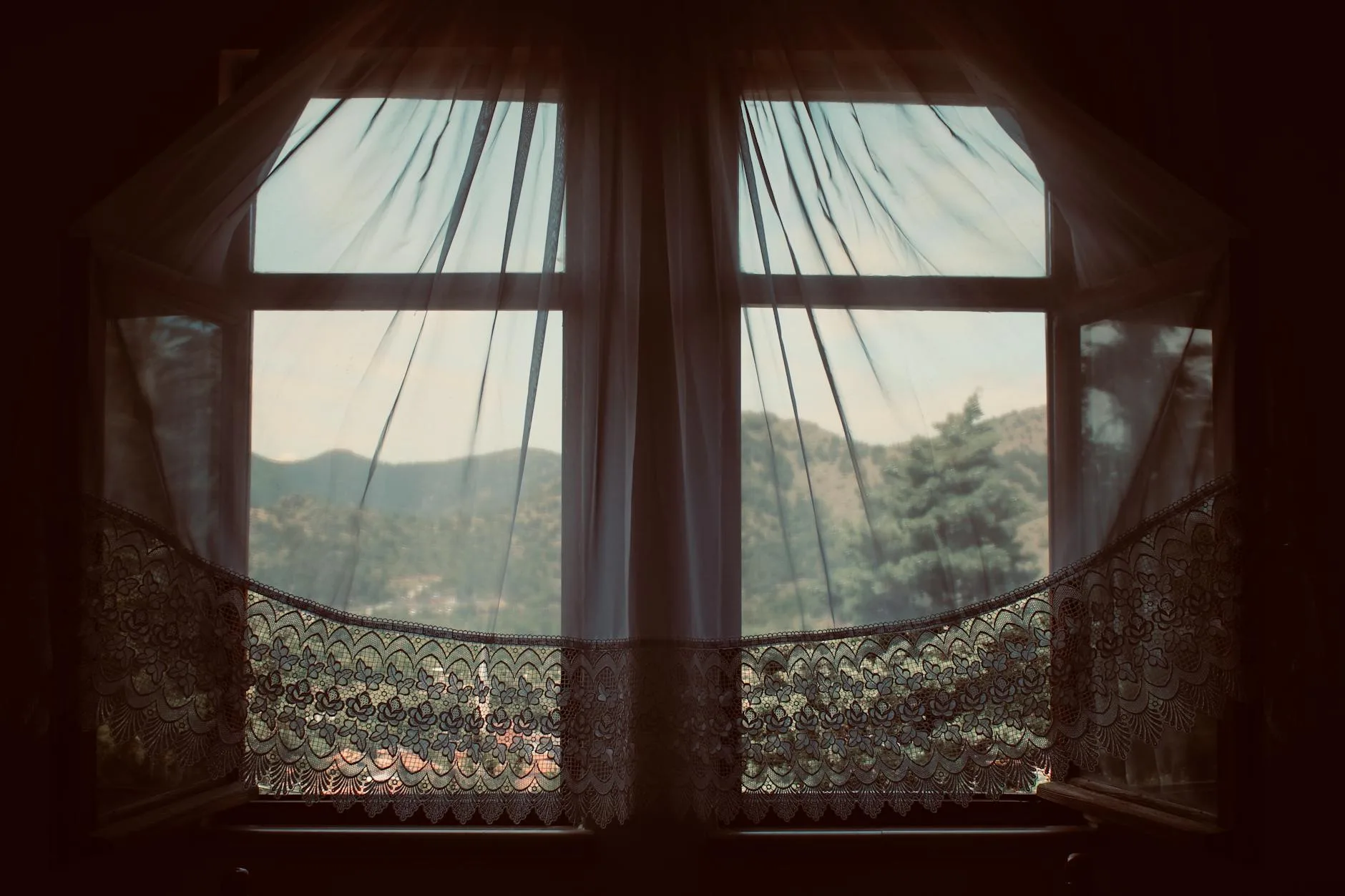 Open window letting fresh air into a room with curtains