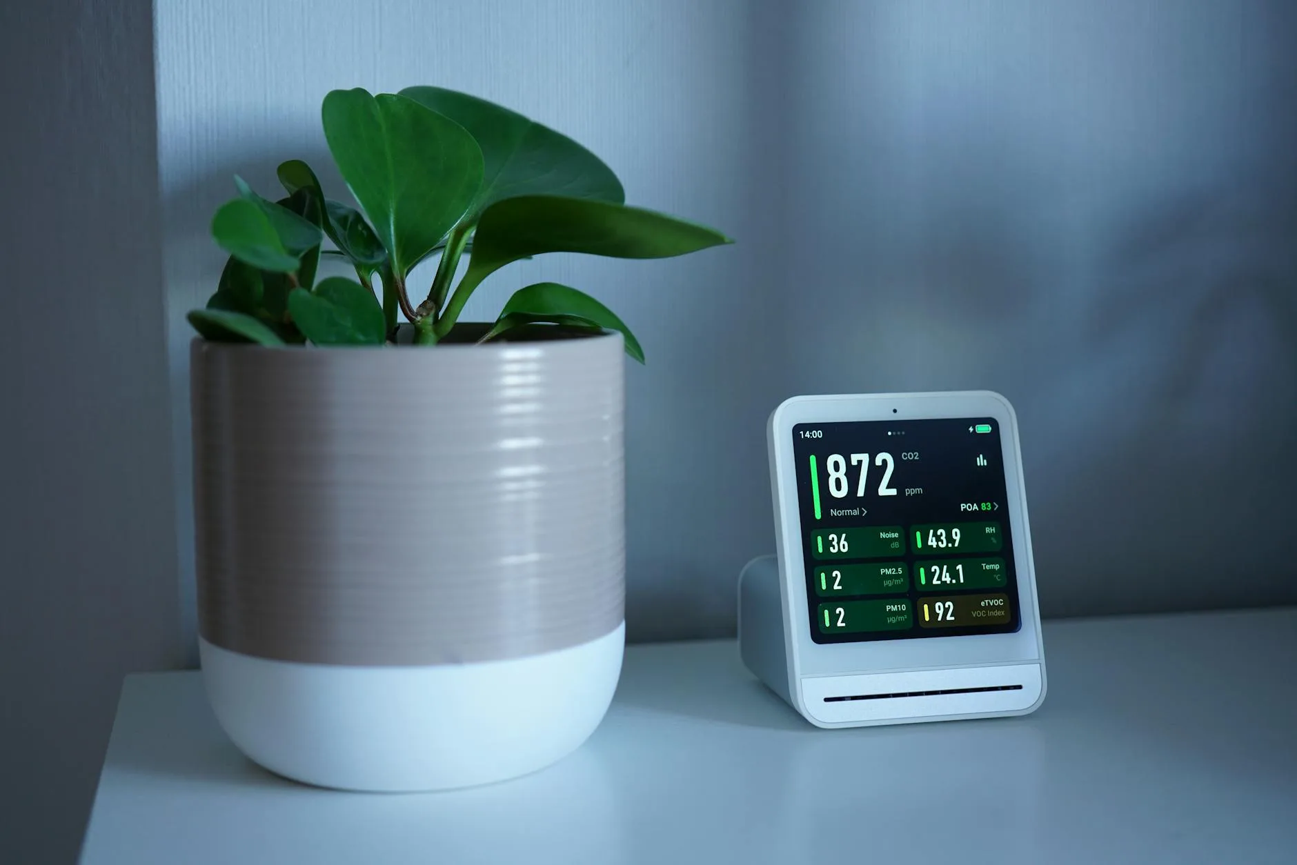 Indoor air quality monitor displaying CO2 and PM2.5 readings