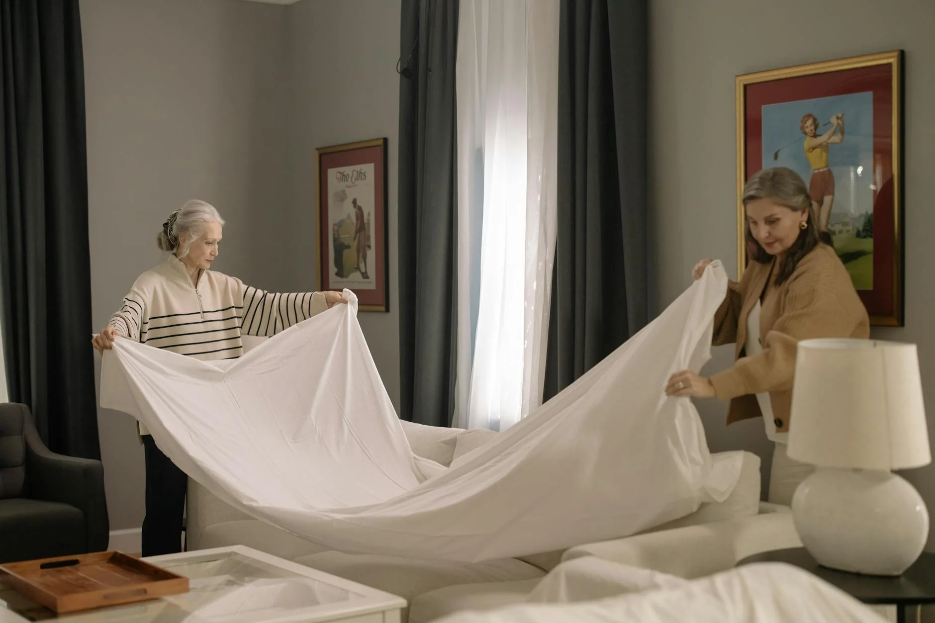 White mattress protector being fitted on a bed