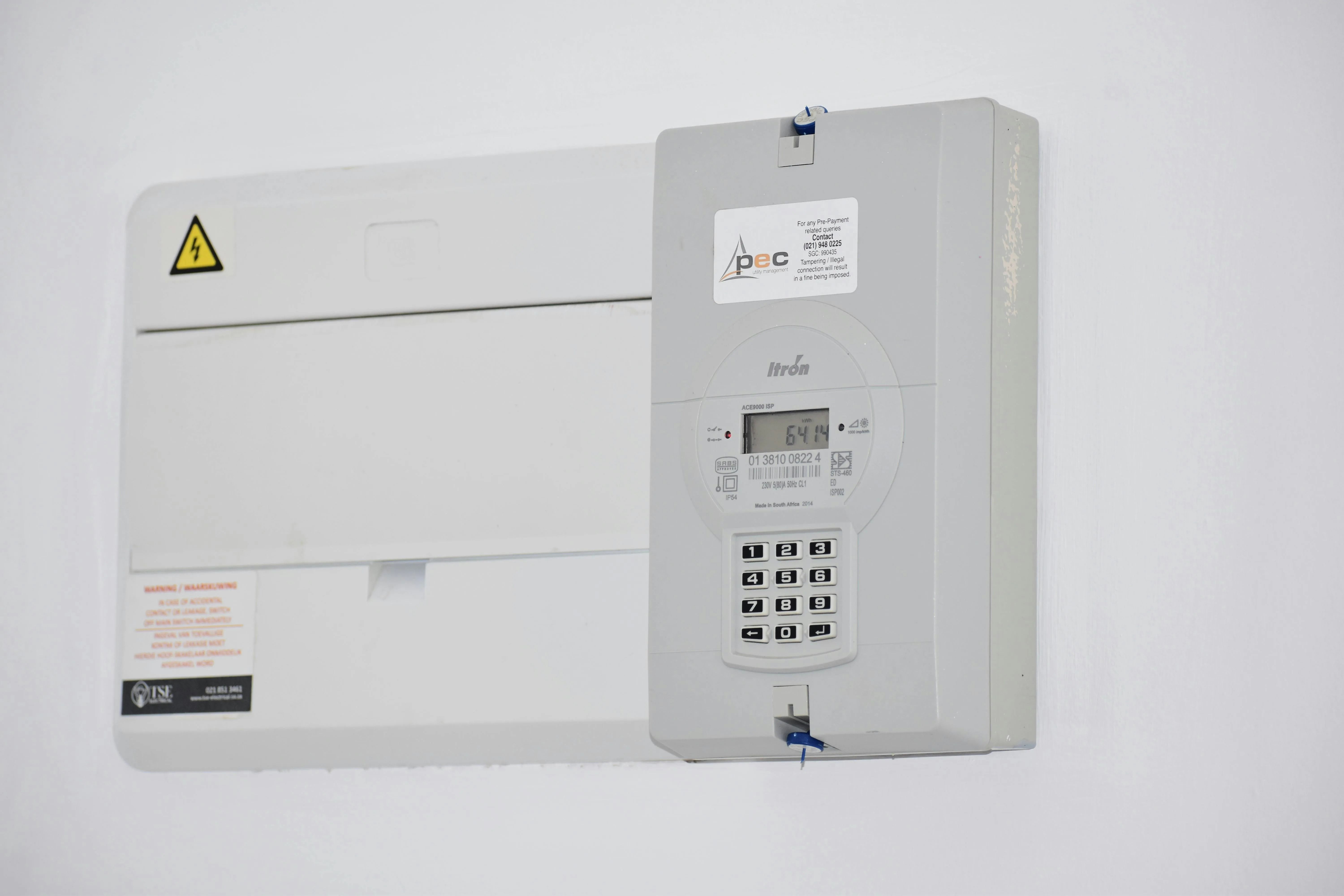 UK electricity meter and consumer unit on a white wall