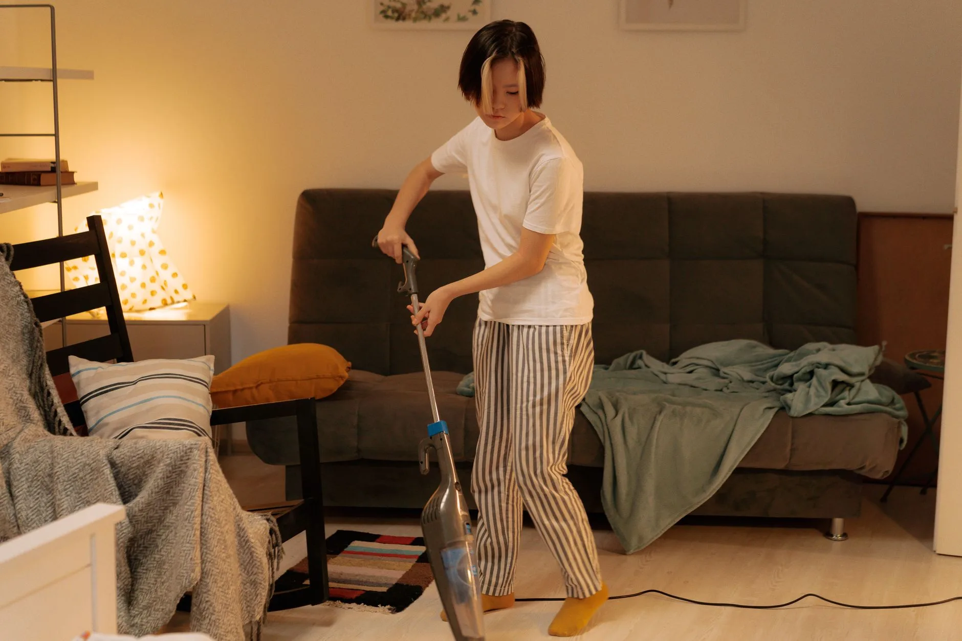 Vacuuming a sofa as part of a pet allergy cleaning routine